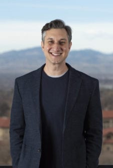 A company founder standing by a mountain range