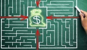 a maze drawn in a green chalkboard, with arrows pointing towards a bag of money in the center